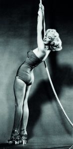 E0MN1W Marilyn Monroe posing in a bathing suit and glass heels